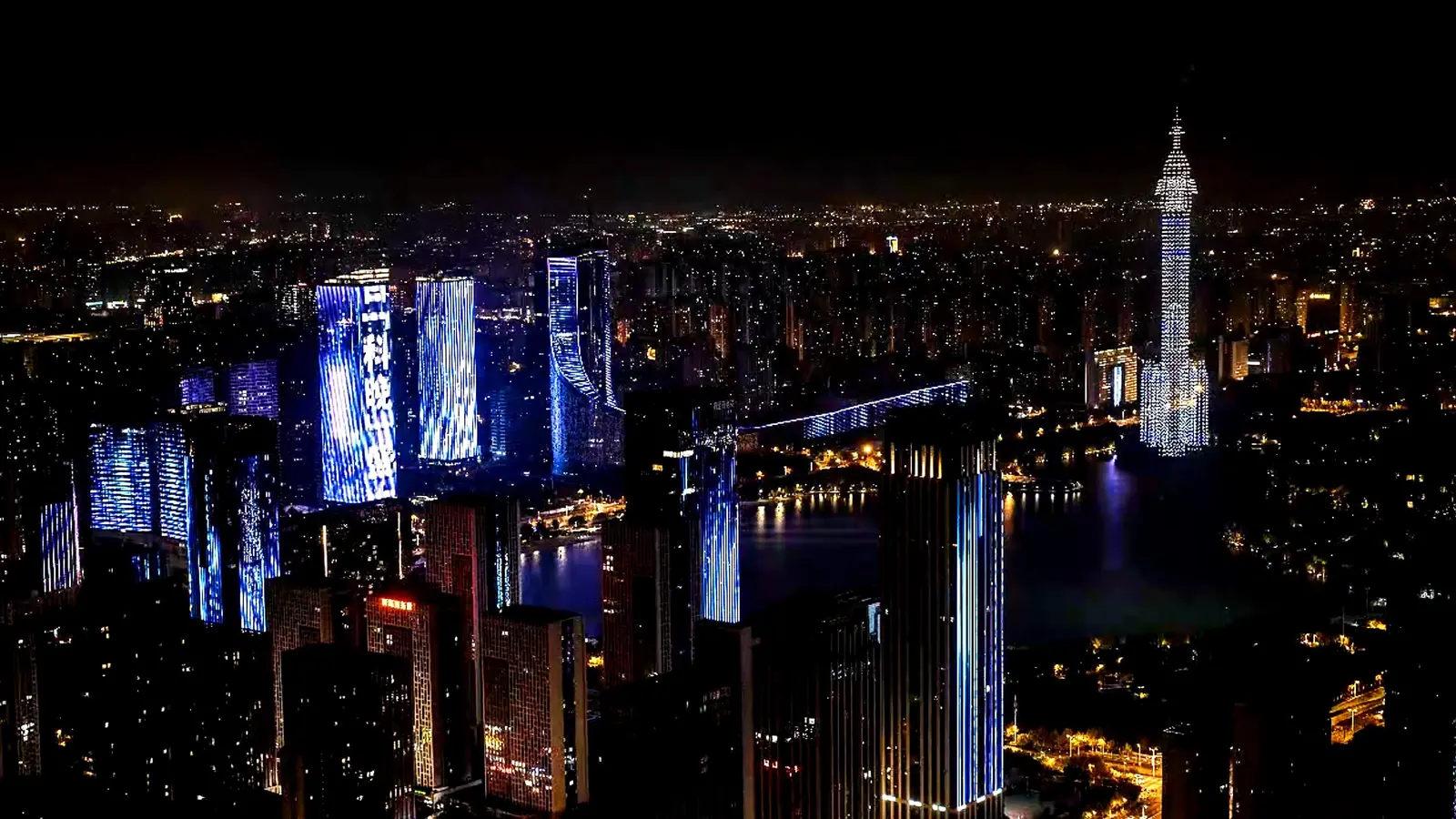 Illuminated drone formation over a city skyline at night